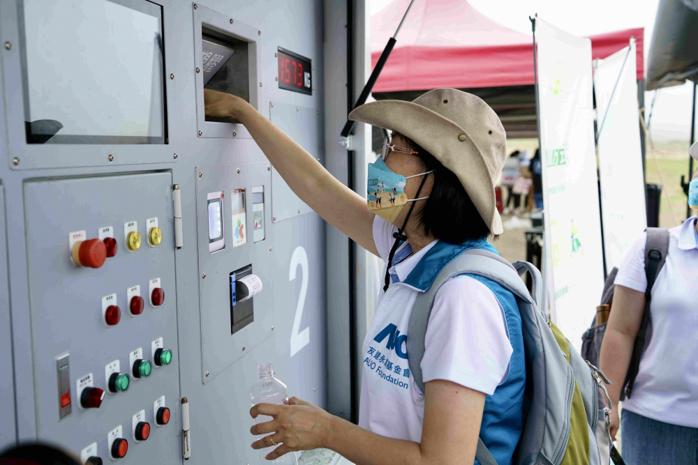 志工們將拾起的寶特瓶投入「好歸塑專車」，讓廢棄塑料空瓶可以直接粉碎、縮小體積，未來將可再製成購物袋、寶特衣、悠遊卡等生活用品